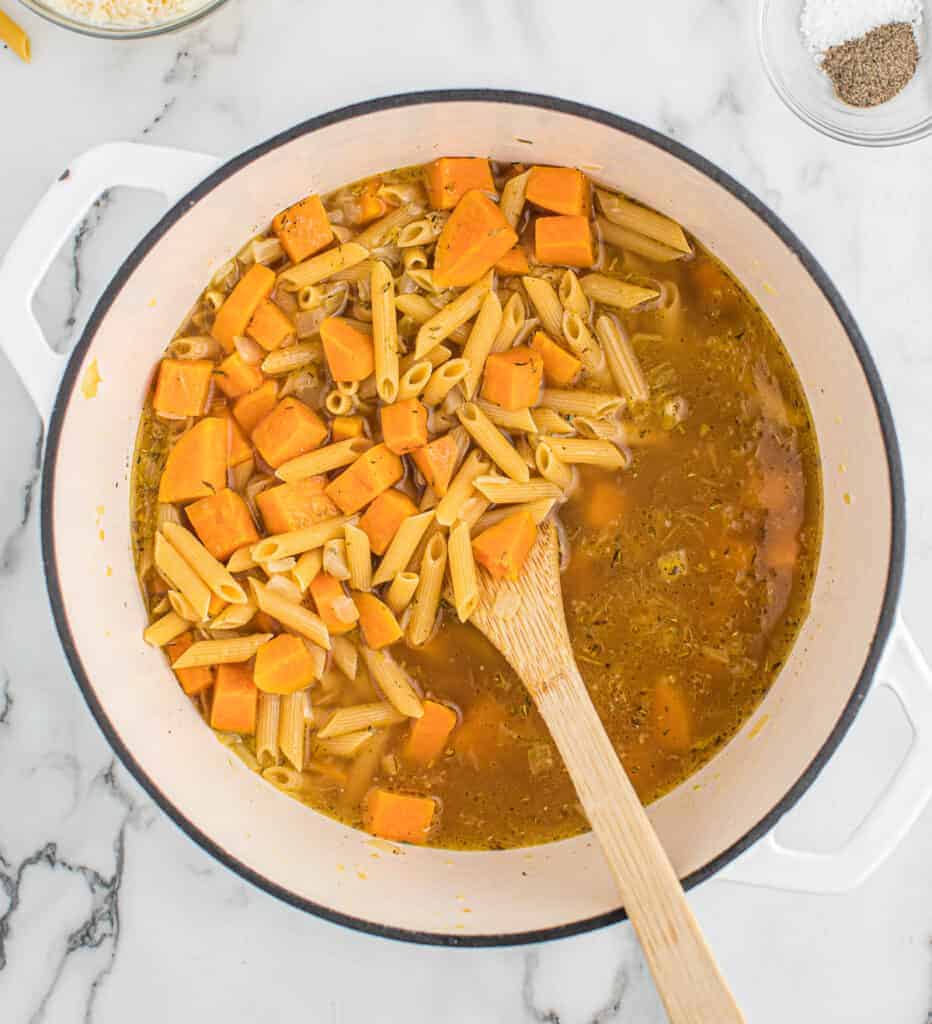 adding the vegetable broth and penne pasta