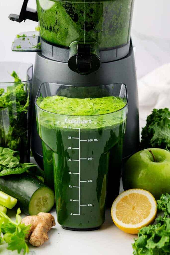 green juice next to a juicer