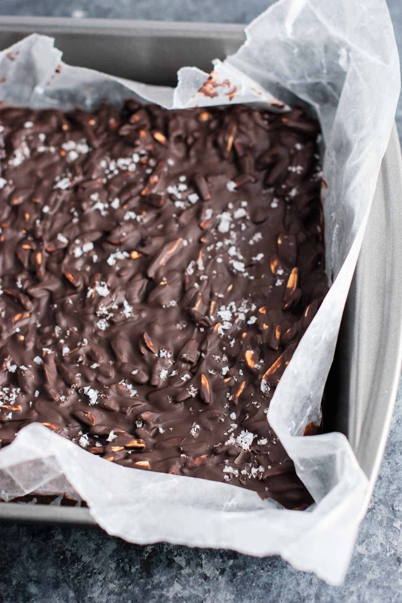 8 by 8 dish lined with wax paper with the finished chocolate almond bark in it