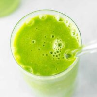 green smoothie in a glass with a straw