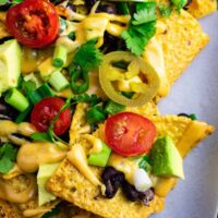 Loaded veggie nachos topped with homemade nacho cheese sauce. These are amazing! #veggienachos #vegetarian #nachocheese #nachocheesesauce