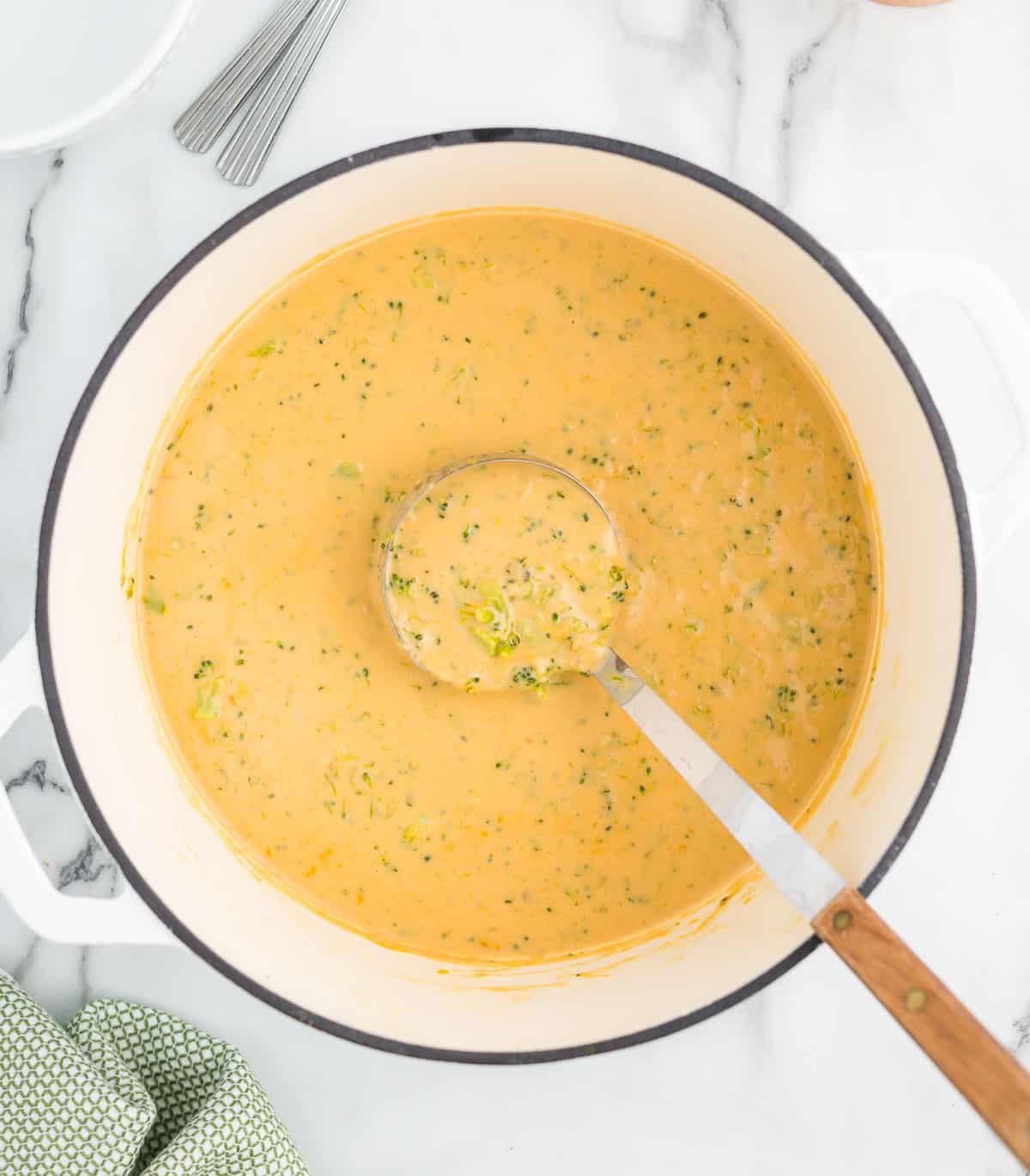 broccoli cheese soup with a ladle