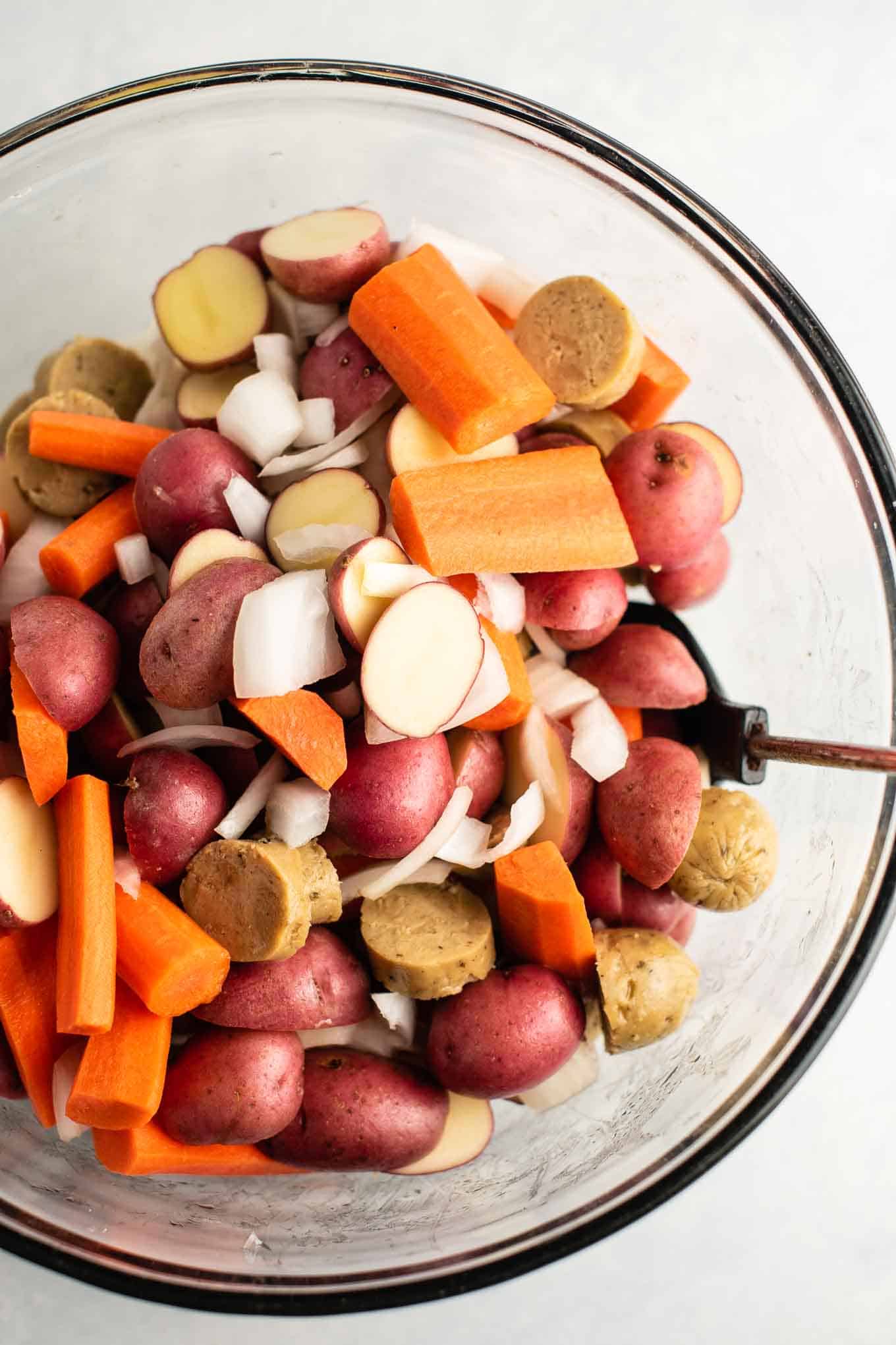 sliced potatoes, carrots, onions, and kielbasa from an overhead view
