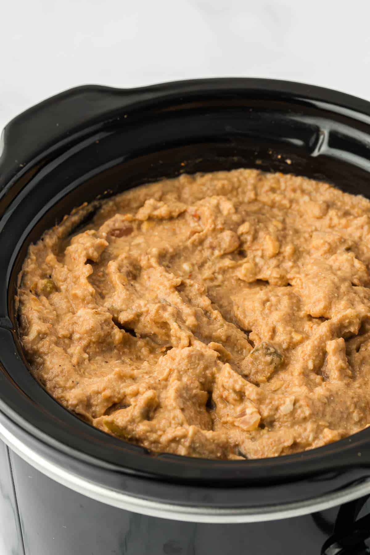 bean dip in a black slow cooker