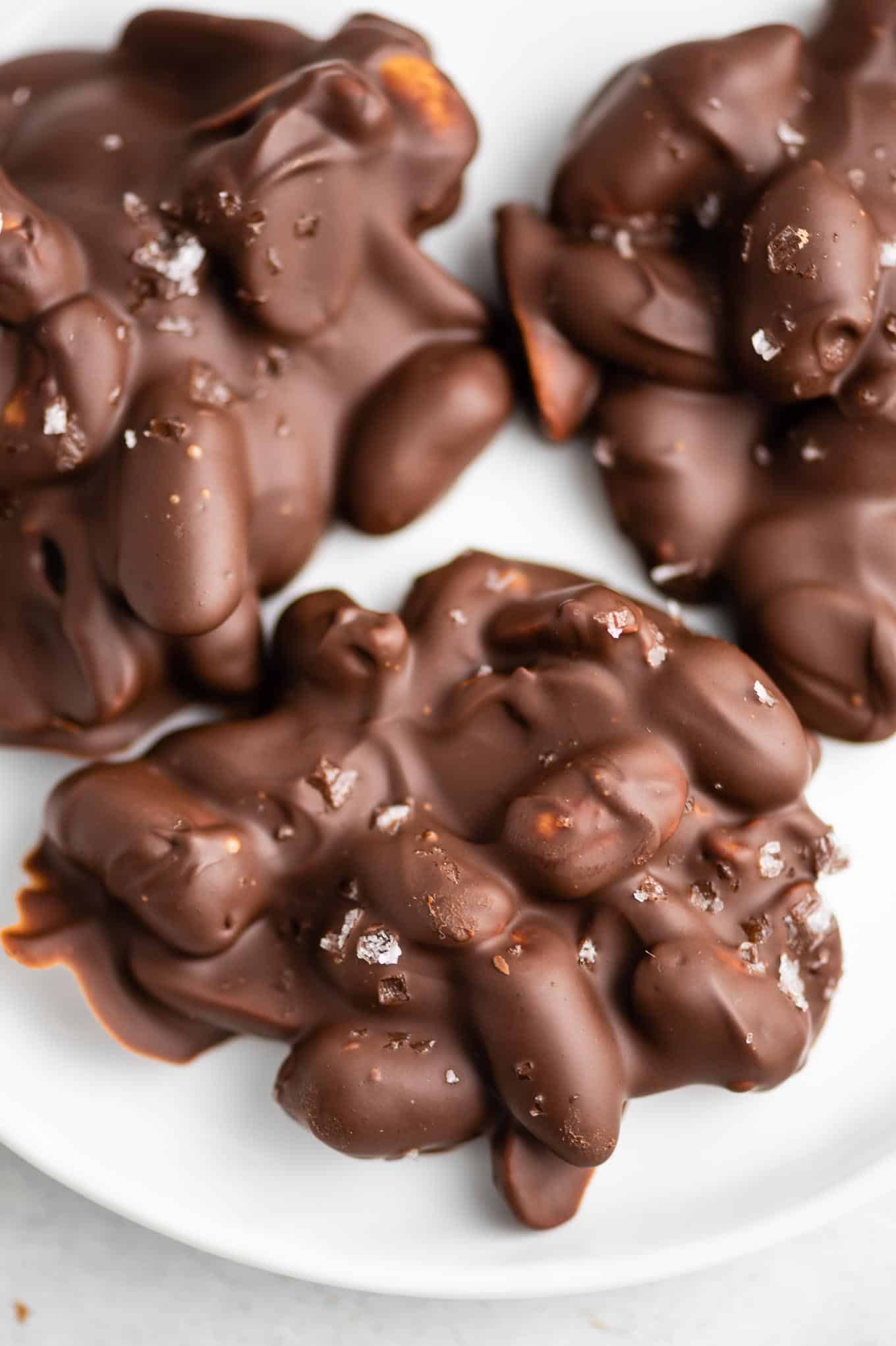 3 peanut clusters on a white plate with sea salt