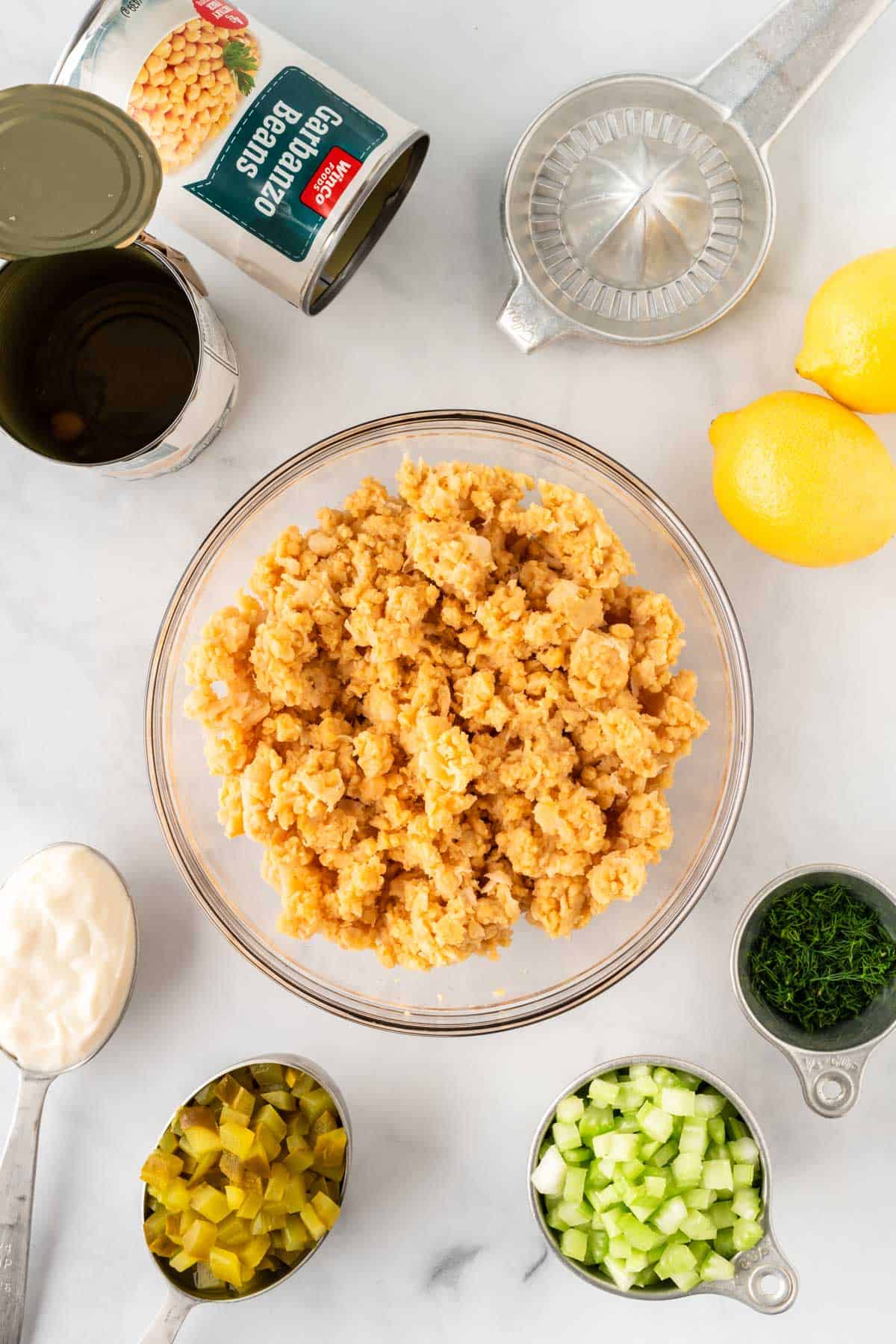 mashed chickpeas in a bowl surrounded by the other recipe ingredients