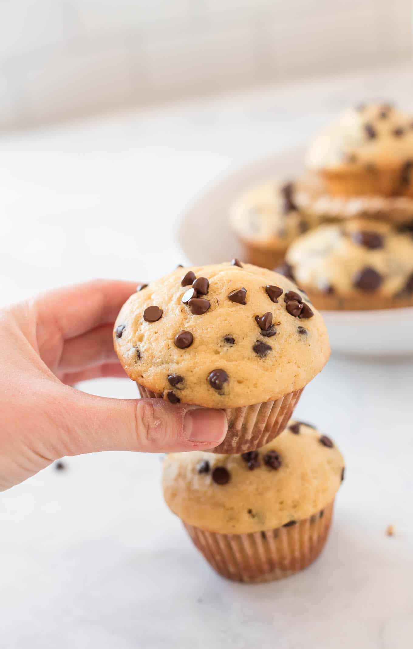 a hand grabbing a muffin