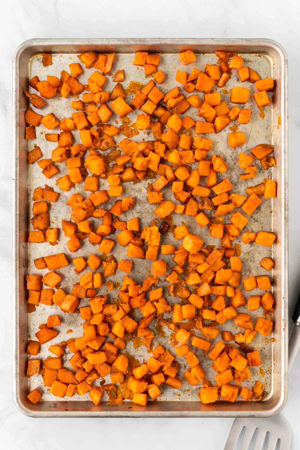 roasted cubed sweet potatoes on a baking sheet