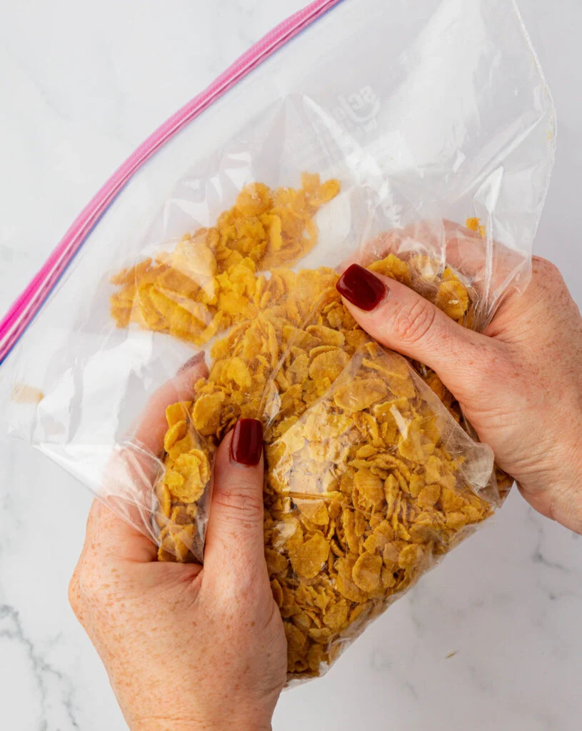 crushing corn flakes inside a bag