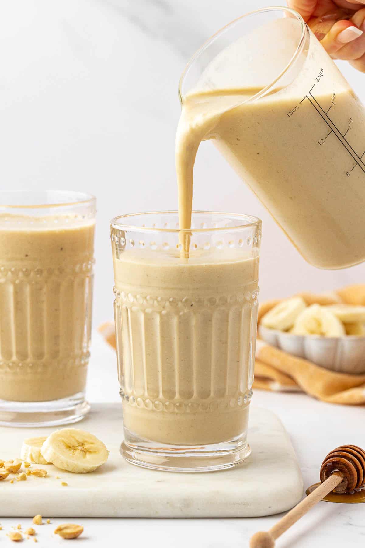 pouring a smoothie into a glass cup