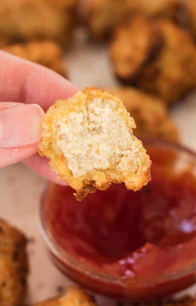 a bite taken out of a tofu nugget to show the meaty texture