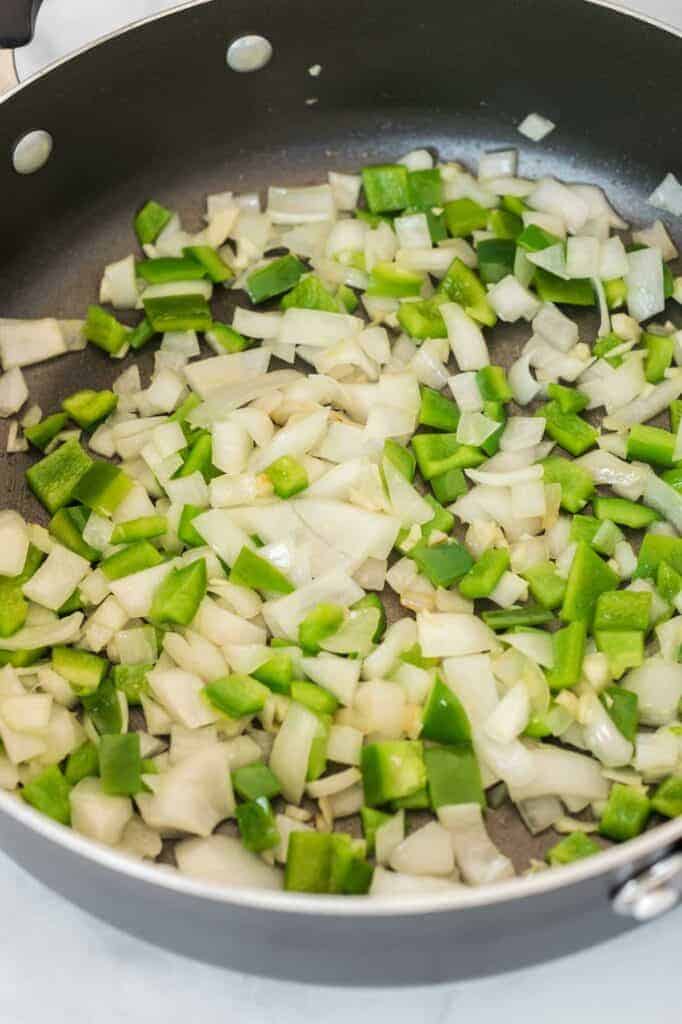 white onion and bell pepper in a skillet