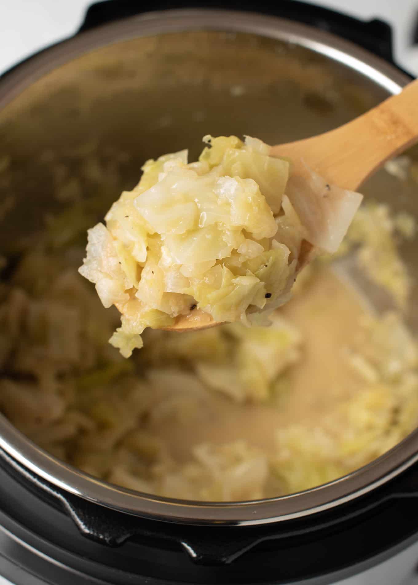 a spoon taking a scoop of buttered cabbage from the instant pot