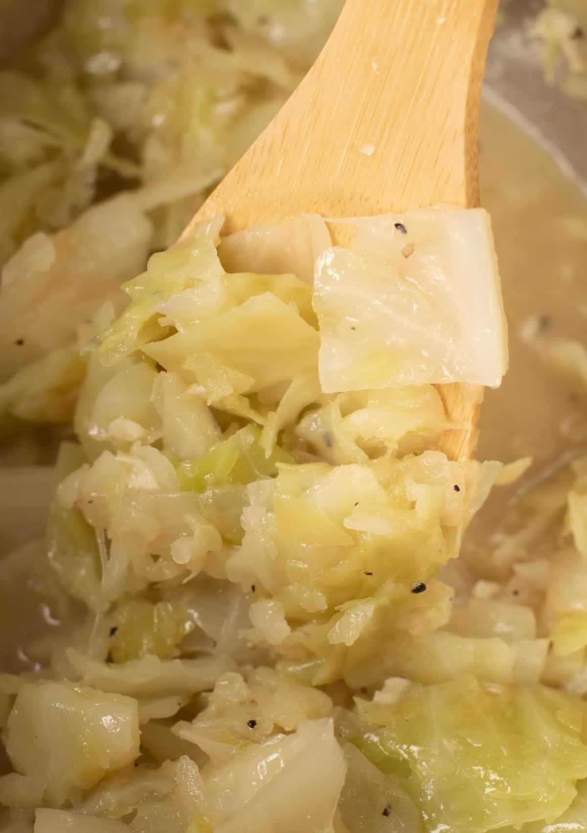 a spoon taking a scoop of buttered cabbage from the instant pot