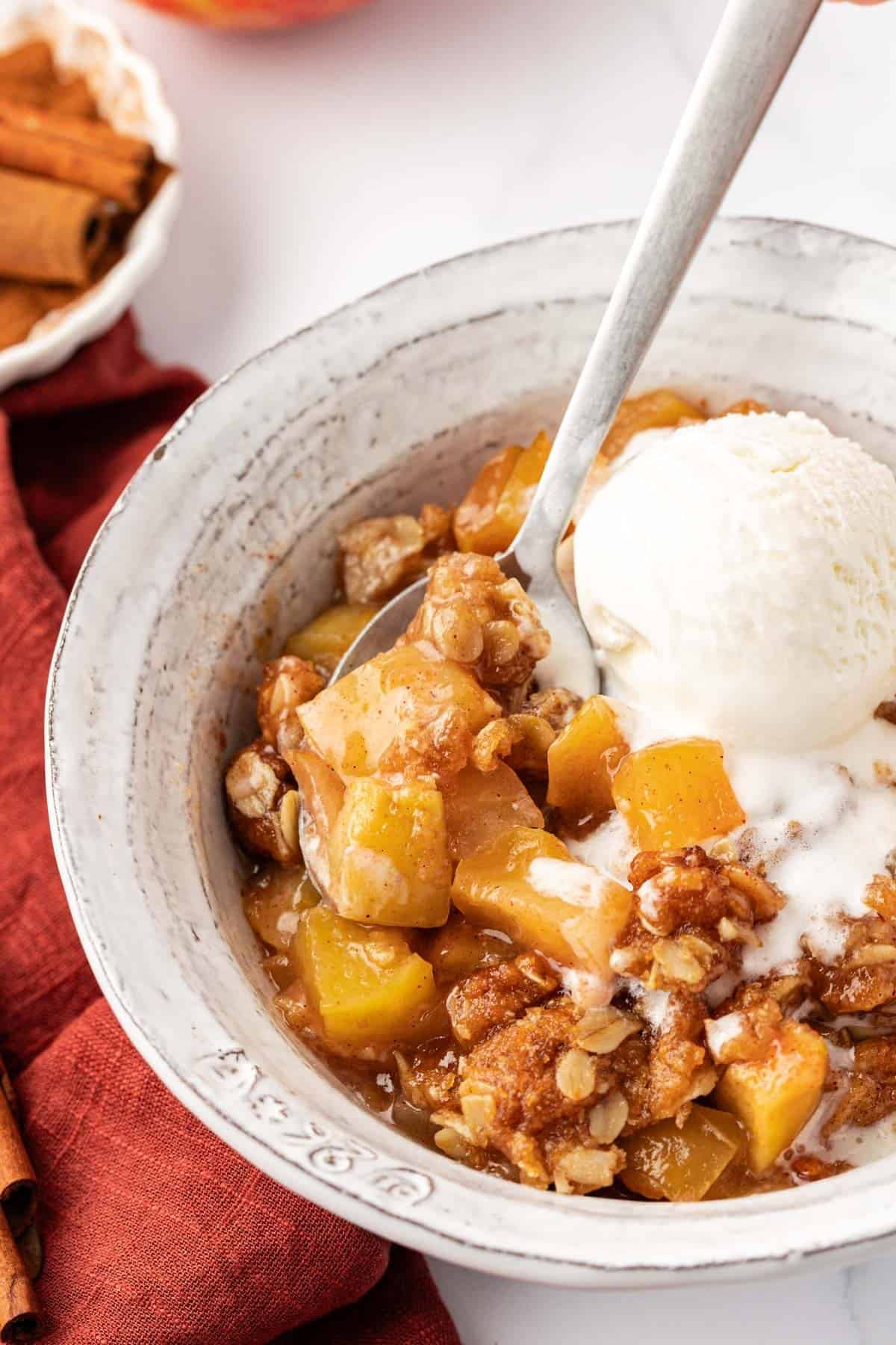 vegan apple crisp topped with a scoop of ice cream