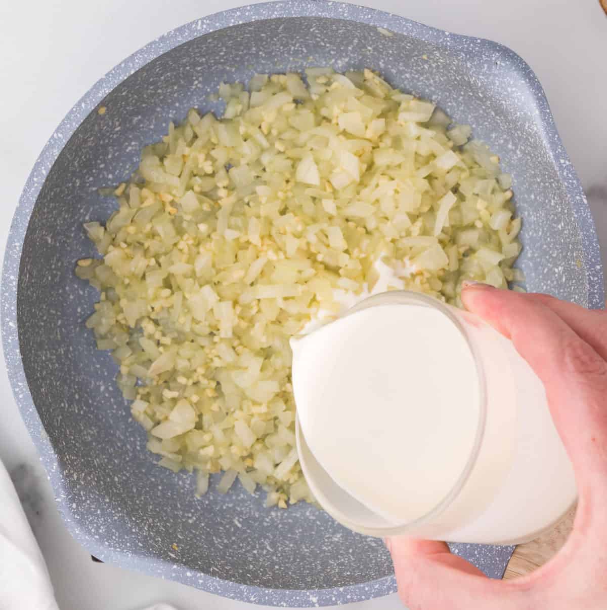 pouring heavy cream into the skillet