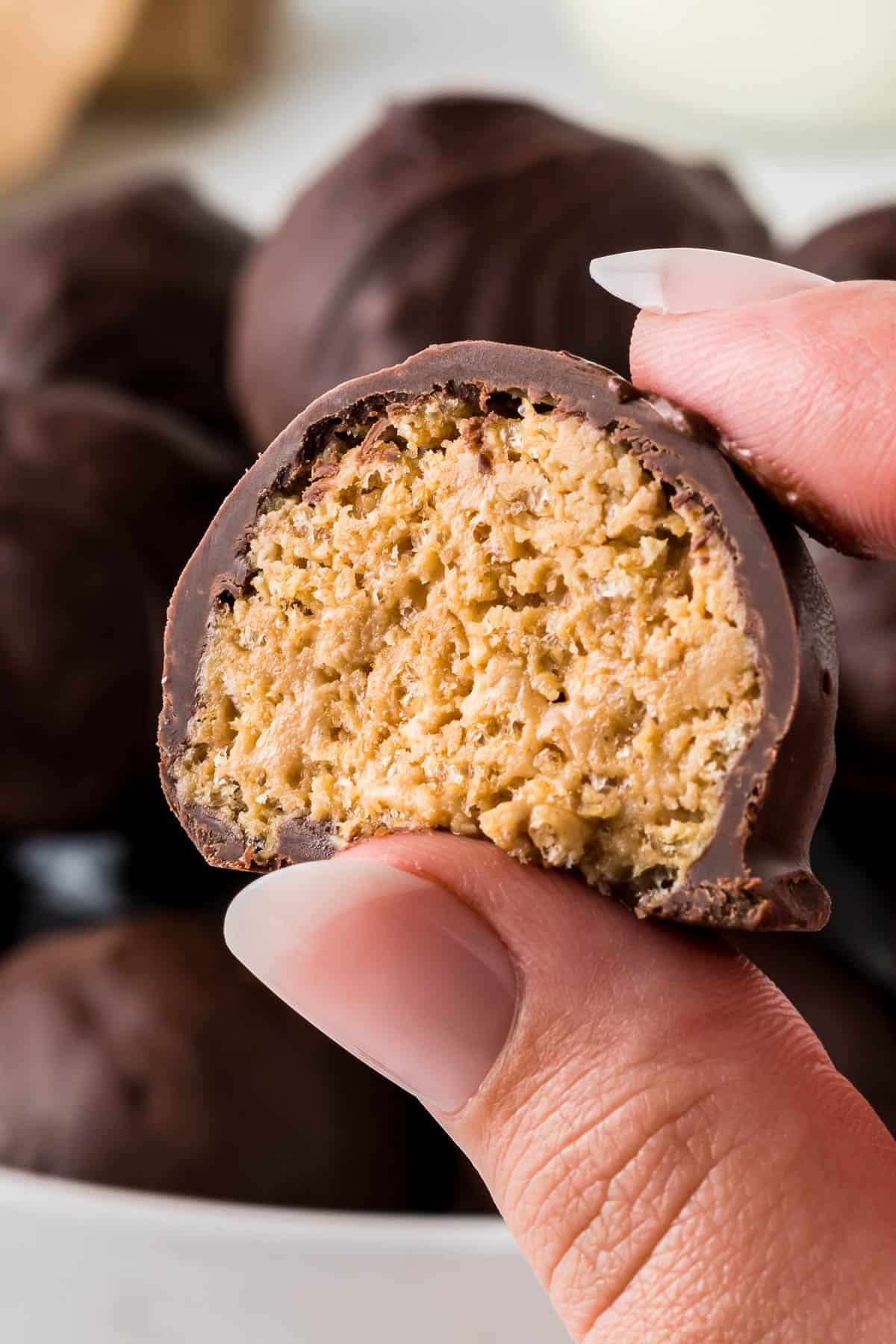 holding a peanut butter ball with a bite taken out