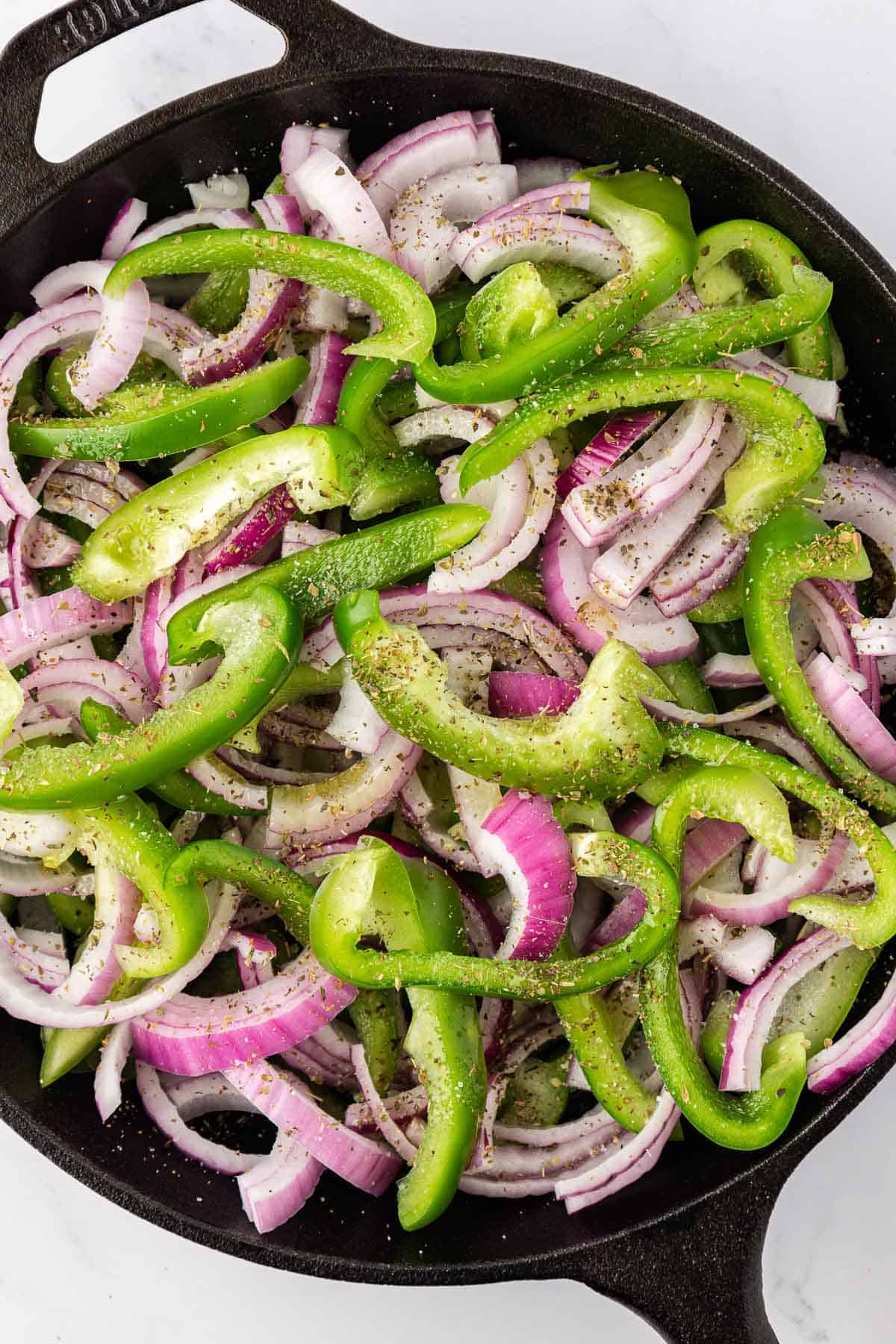 green bell pepper, red onion, and spices in a skillet