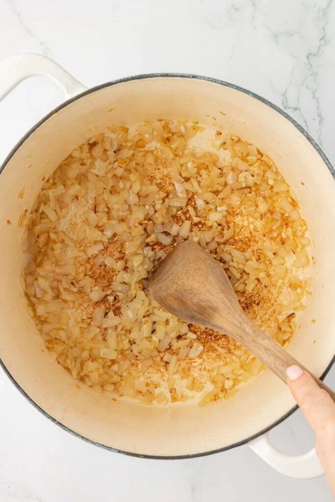 stirring cooked down garlic and onion in a dutch oven