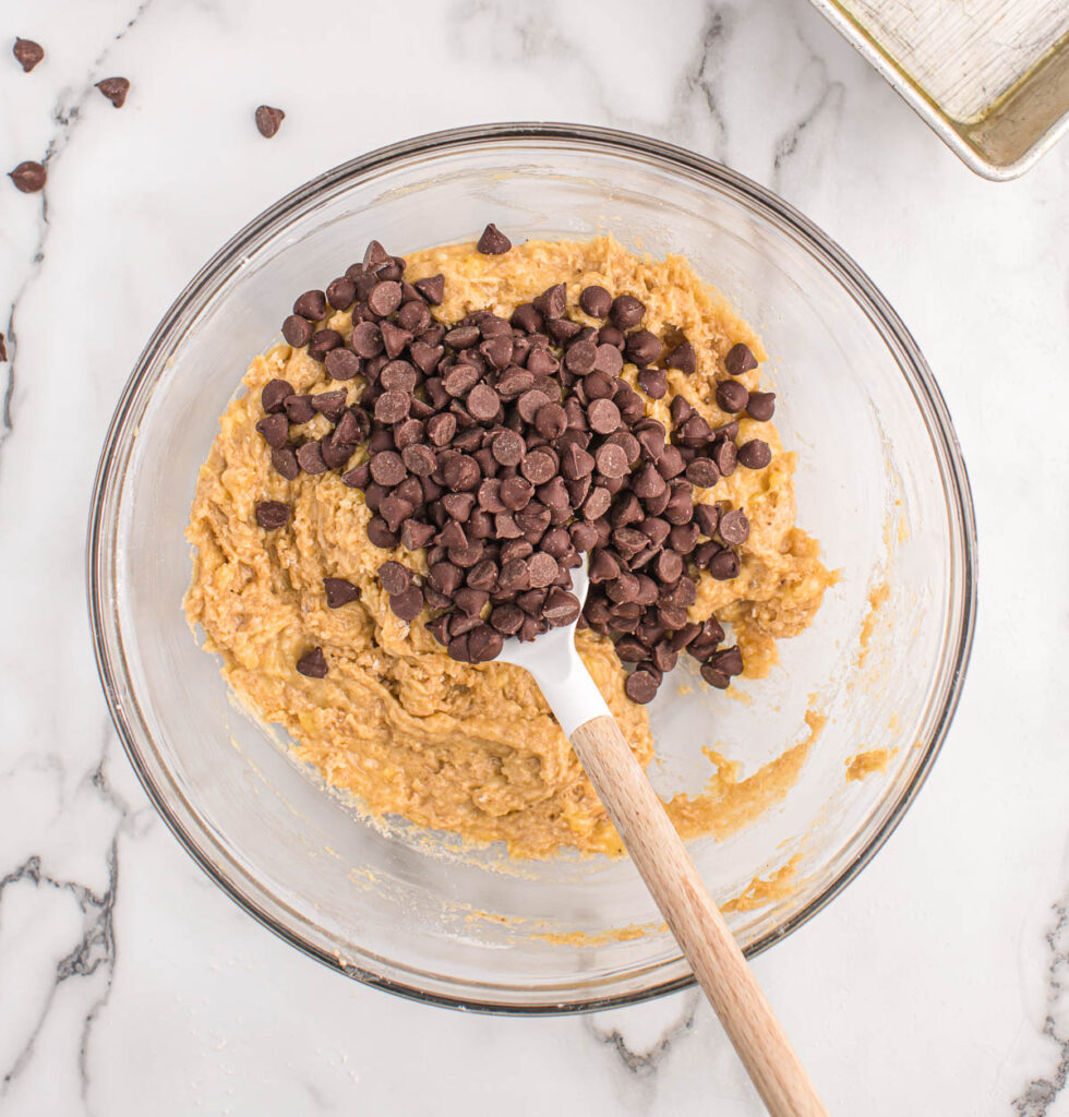stirring chocolate chips into banana bread batter
