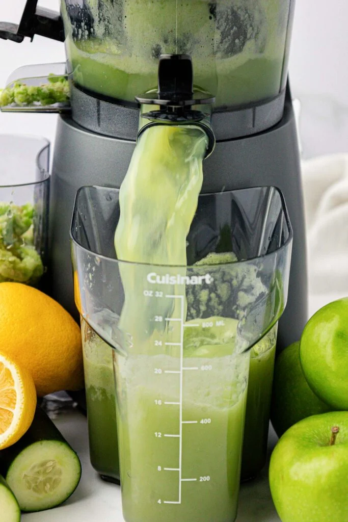 juice pouring out of a juicer into a canister