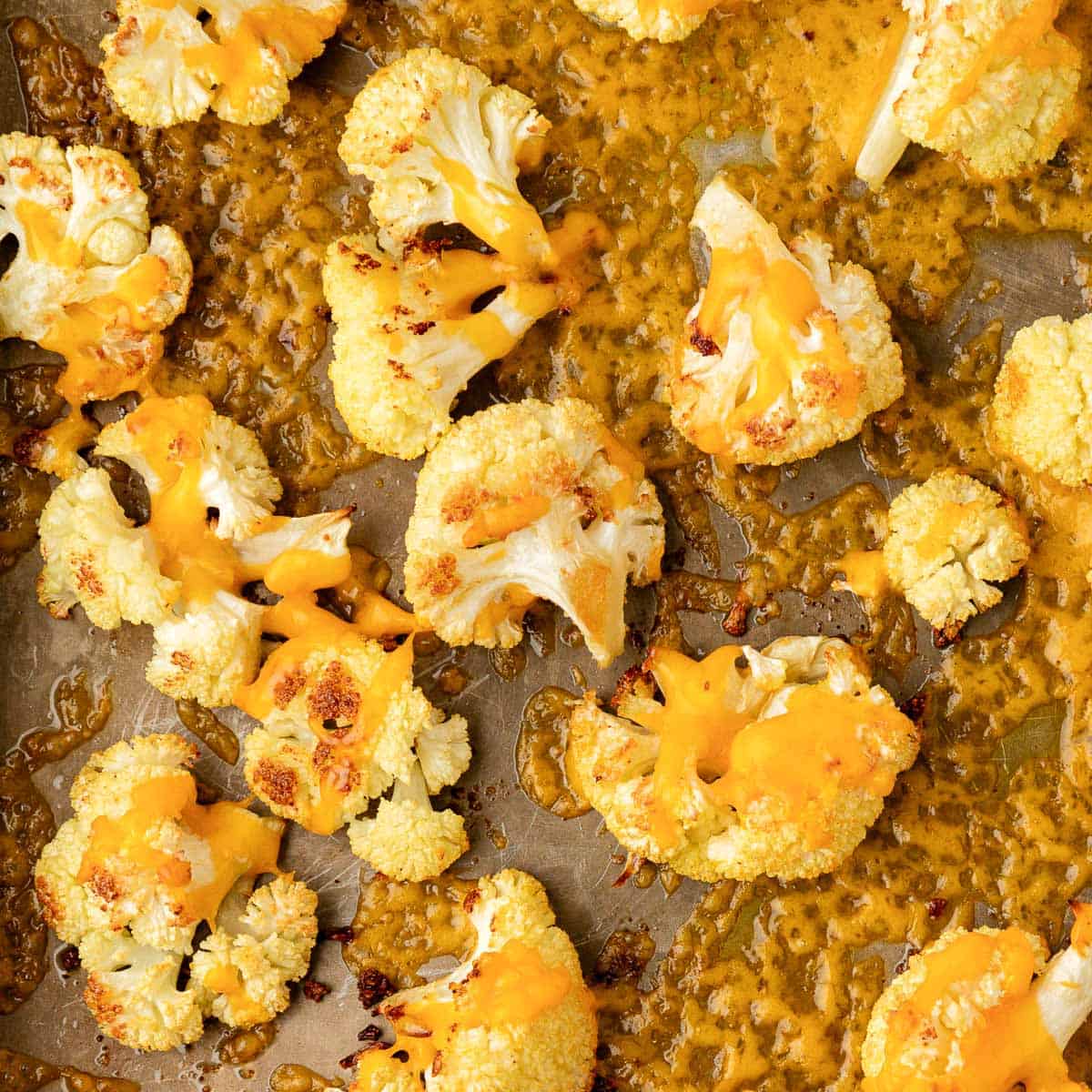 roasted cauliflower with cheese on a baking sheet