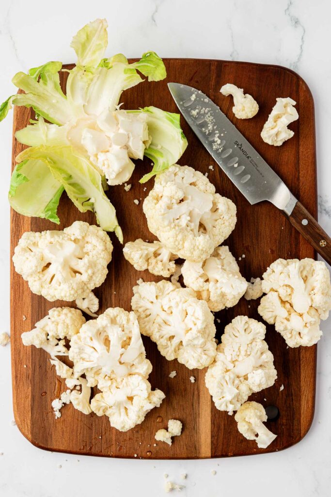 cutting cauliflower on a cutting board