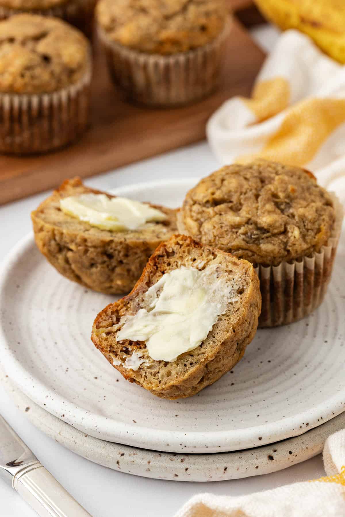 banana muffin cut in half and topped with butter