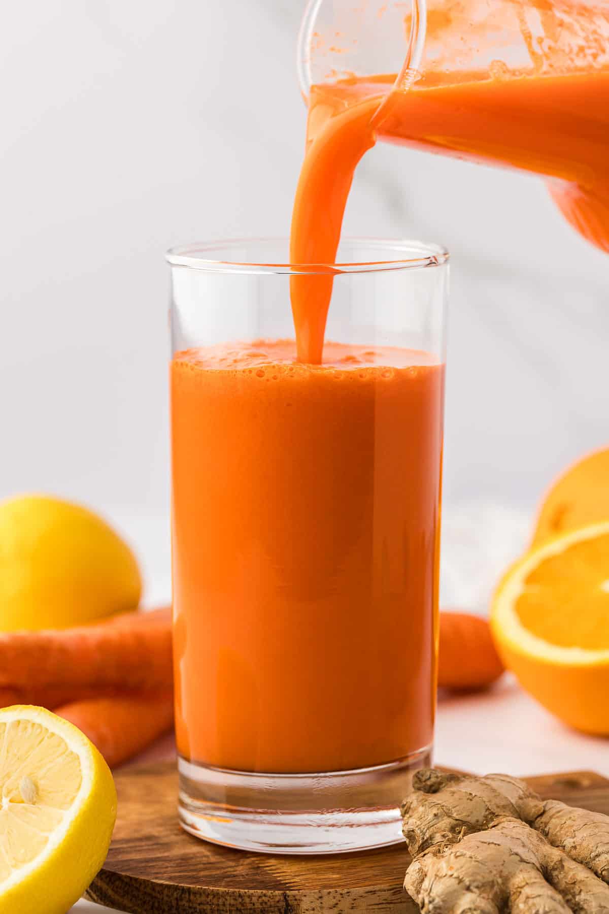 pouring carrot orange juice into a glass