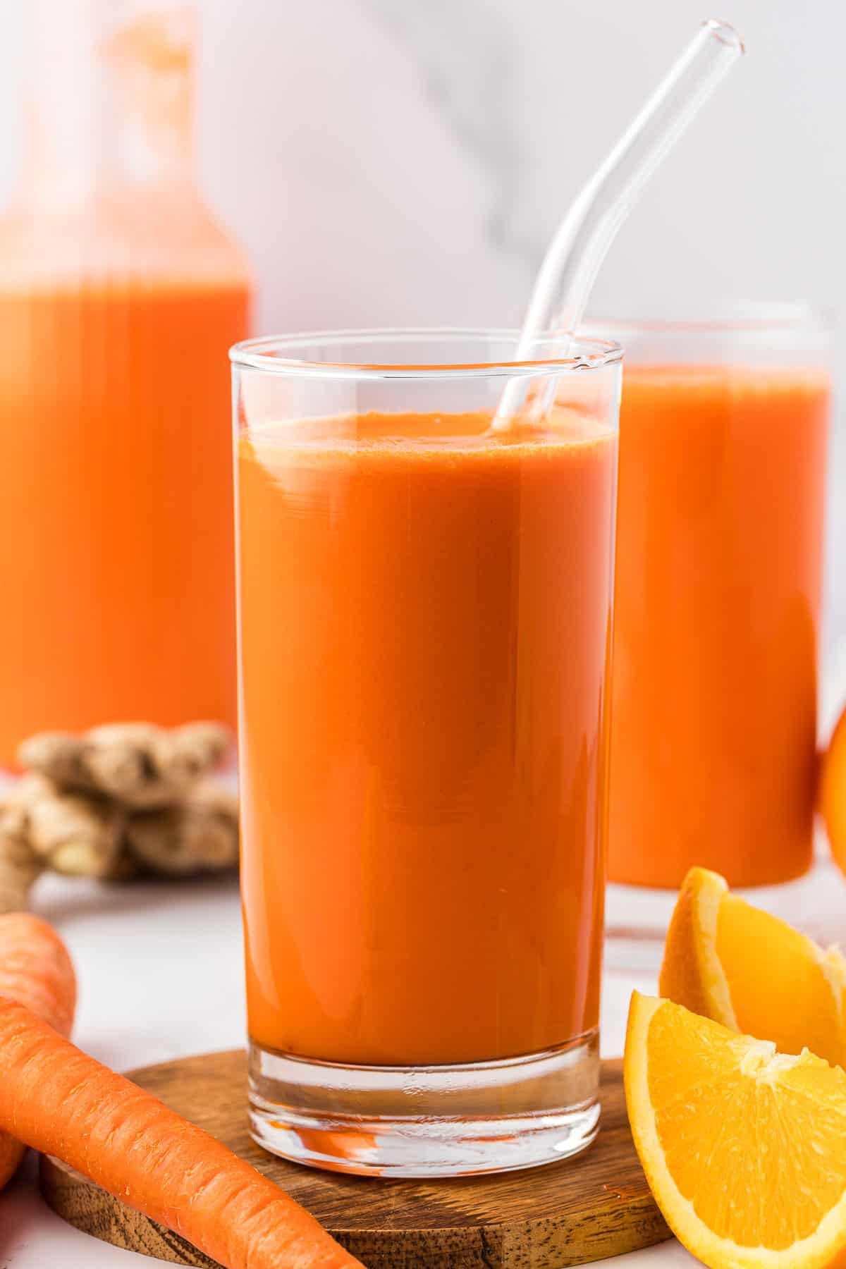 carrot orange juice in a glass with a straw