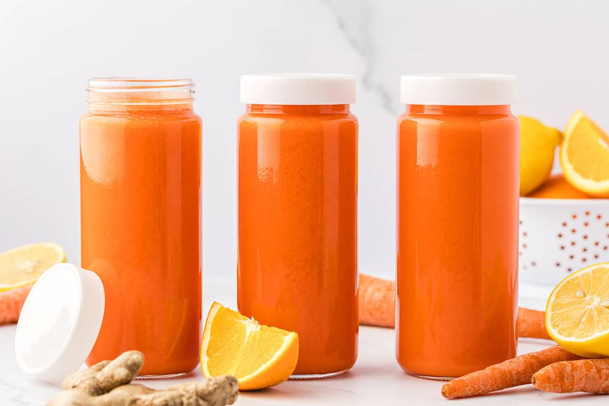 carrot orange juice in 16 oz storage glasses with lids