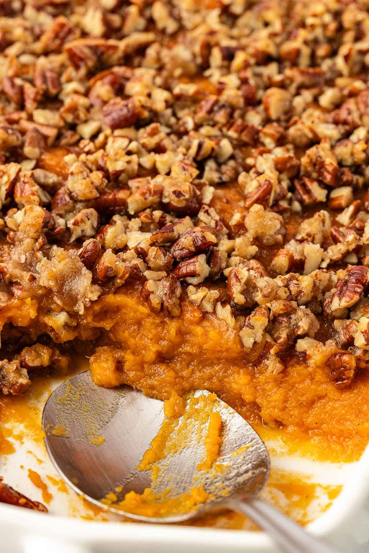 sweet potato casserole with pecans with a scoop taken out