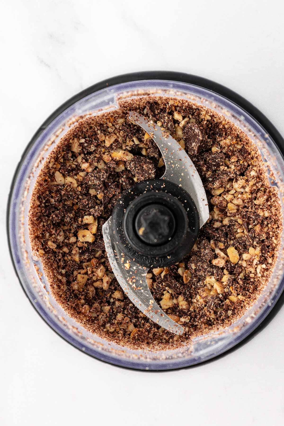 chopped up dark chocolate chips and cashews in a food processor