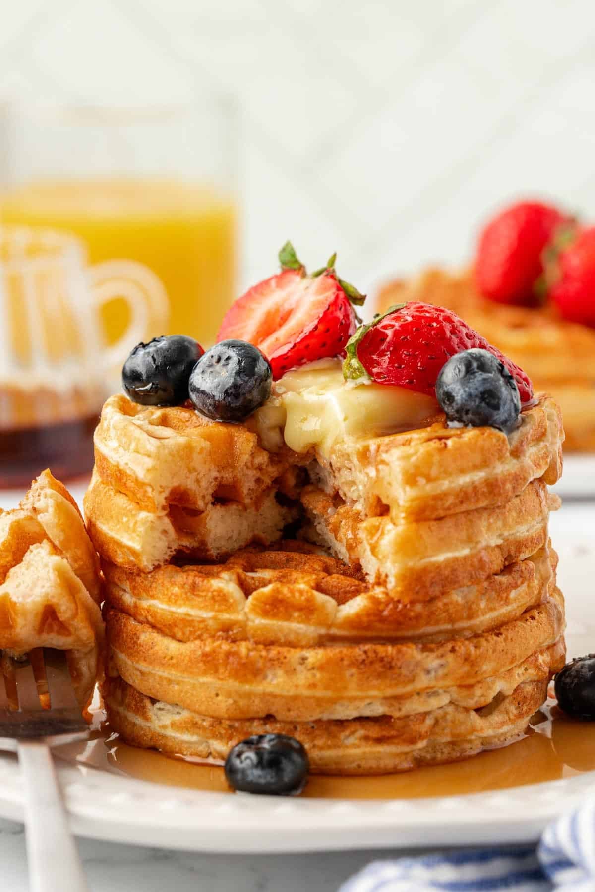 Greek yogurt waffles topped with fruit, syrup, and butter
