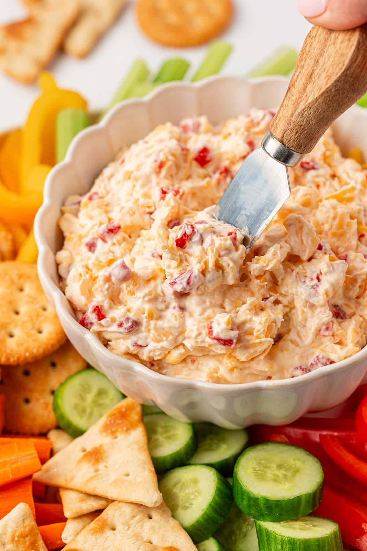 pimento cheese dip on a platter with crackers and vegetables