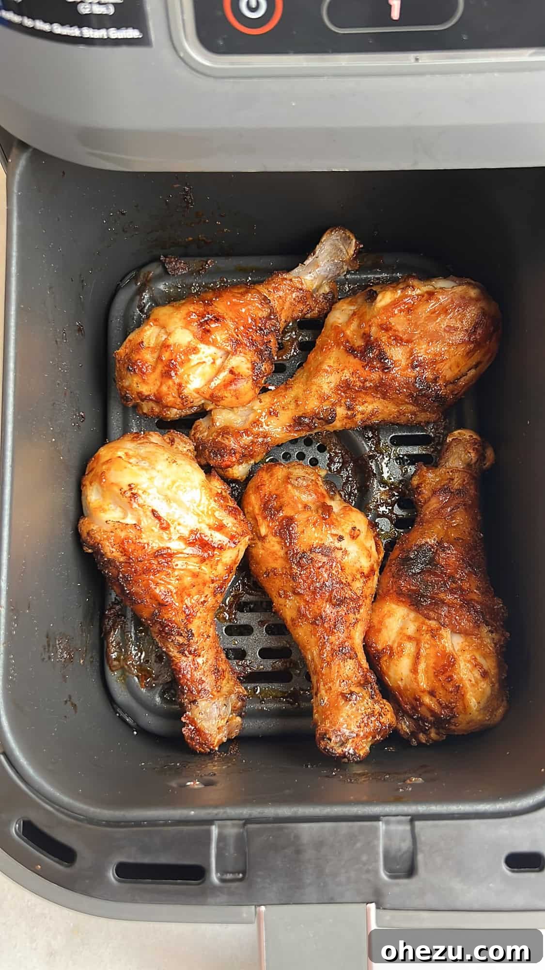Crispy Air-Fried Sweet Chili Wings 8 Crispy chicken wings cooking in an air fryer basket, showing a golden brown and crunchy texture.