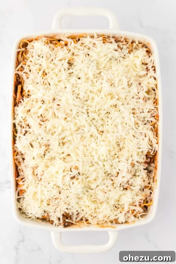 The top of the spaghetti bake generously covered with the remaining mozzarella cheese, ready for baking.