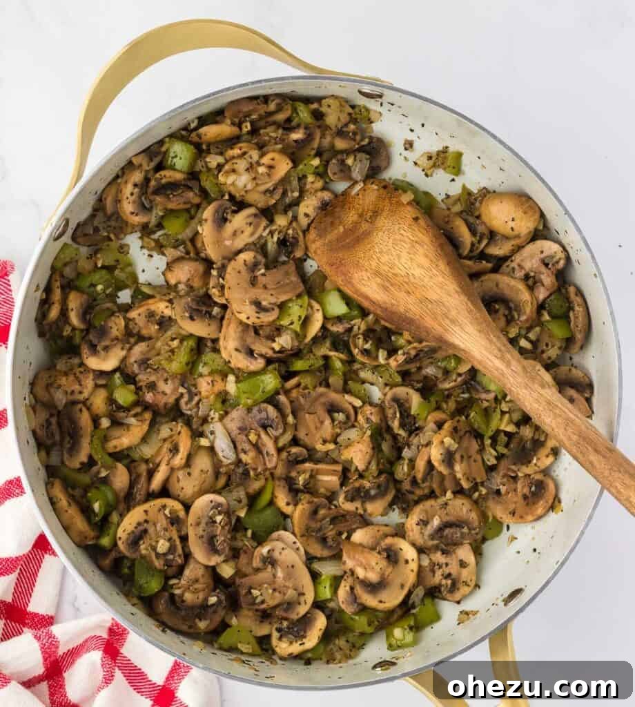 Cooked and tender vegetables in a skillet, having released their moisture and softened.