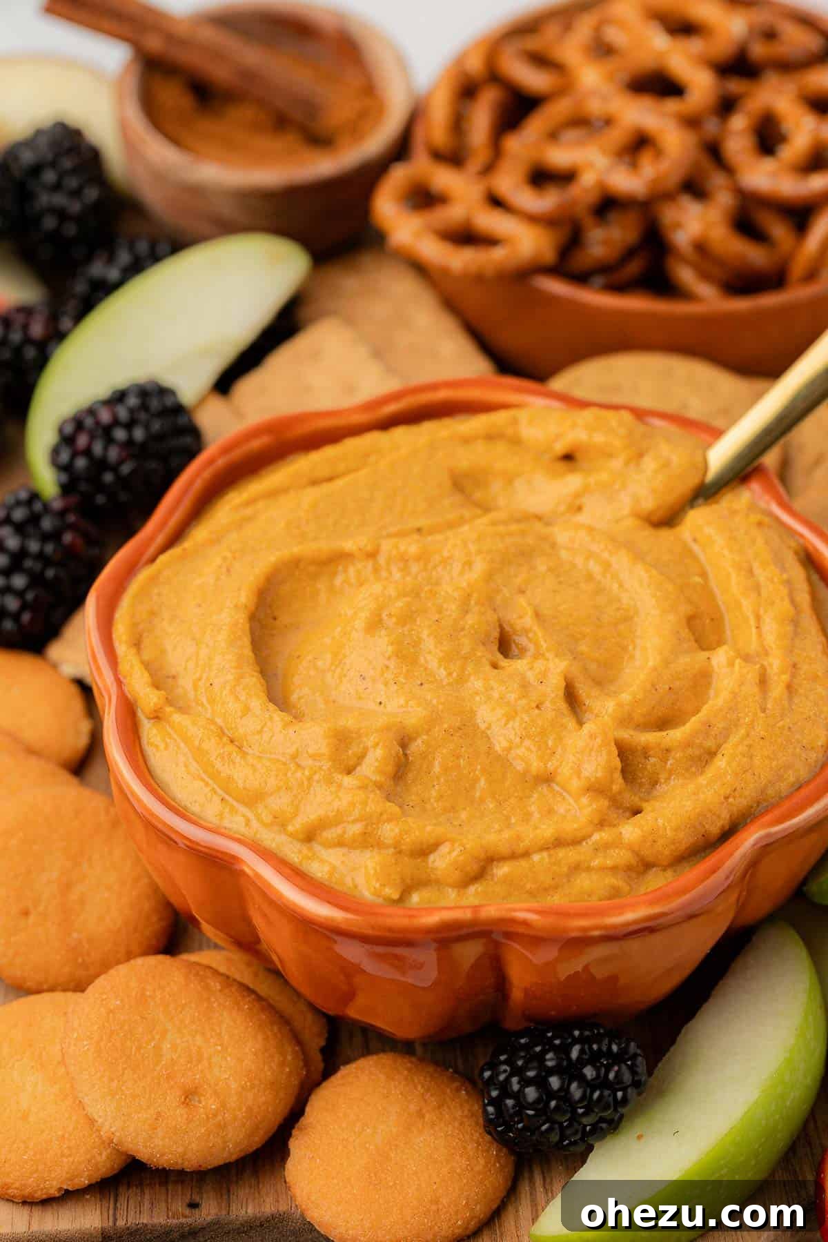 A cozy close-up of a rustic bowl filled with creamy pumpkin cream cheese dip, ready to be enjoyed