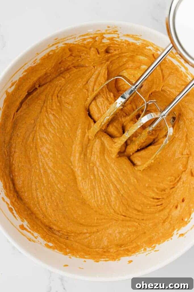 Mixing the cream cheese, pumpkin, and spices together until smooth and well combined
