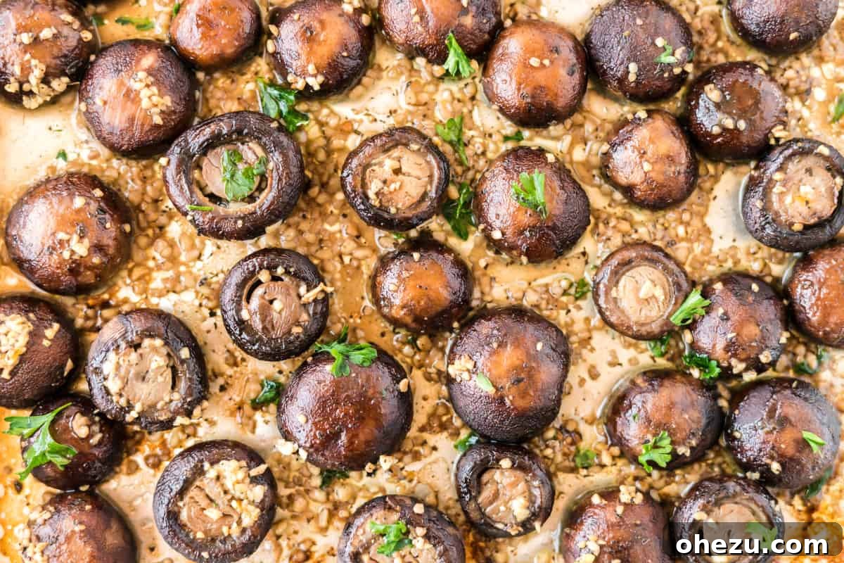Plant-Powered Perfection 3 Close-up shot of roasted garlic mushrooms perfectly browned on a baking sheet, showcasing their rich texture and golden edges, a fantastic vegetarian side dish.