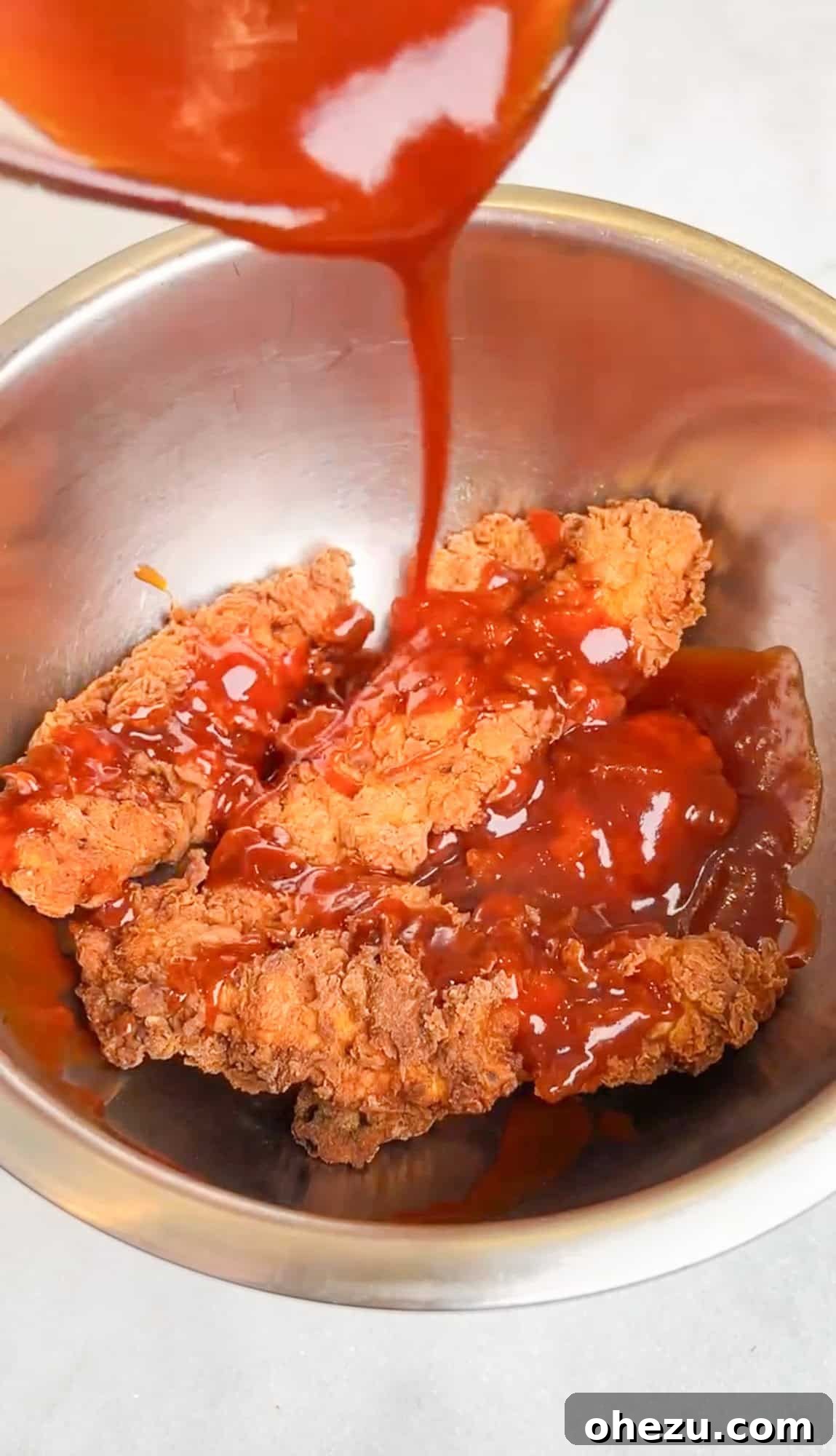 Homemade Honey Chipotle Chicken Crispers 7 honey chipotle chicken crispers being tossed in sauce