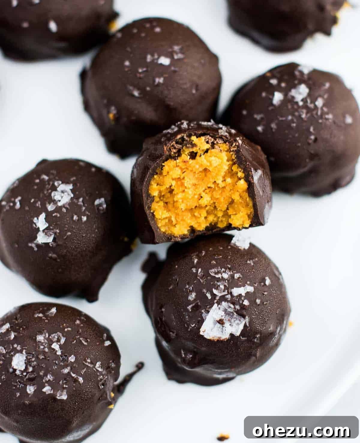 Dark chocolate pumpkin truffles delicately arranged on a plate, ready to be enjoyed.