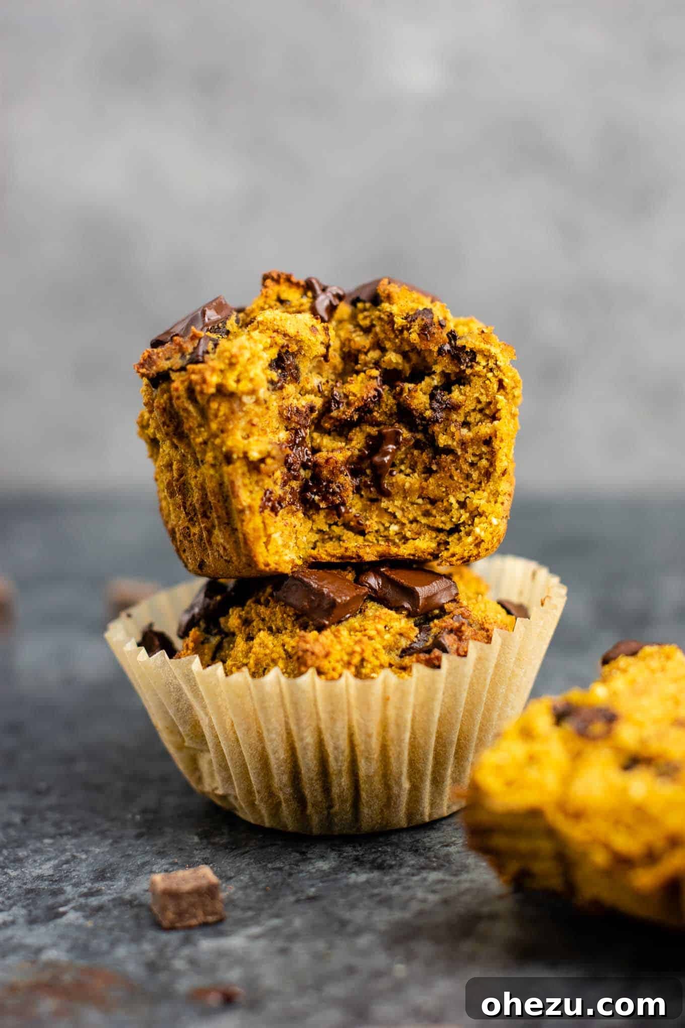 Wholesome Gluten-Free Pumpkin Muffins 5 Several gluten-free pumpkin muffins stacked on a wooden board, ready to be enjoyed.