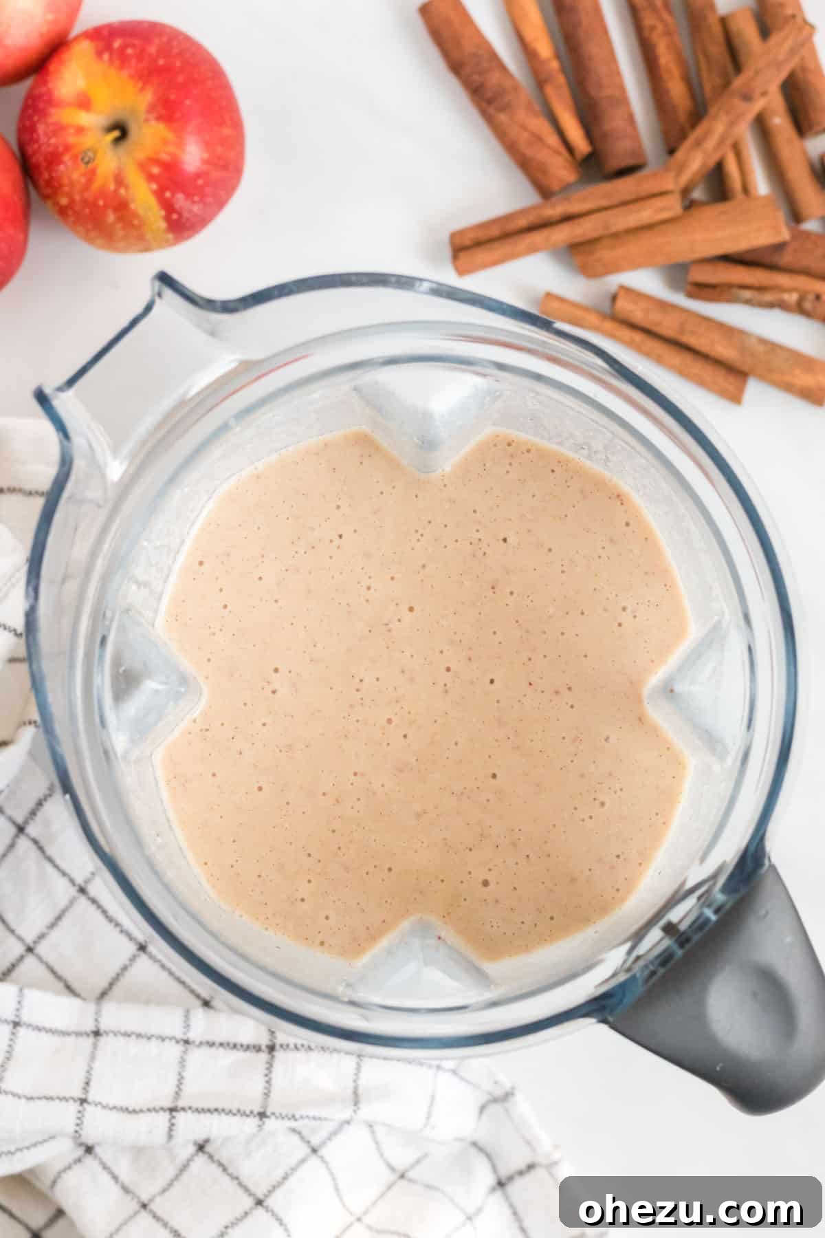 The apple pie smoothie blending inside a high-speed blender, creating a thick and creamy texture.