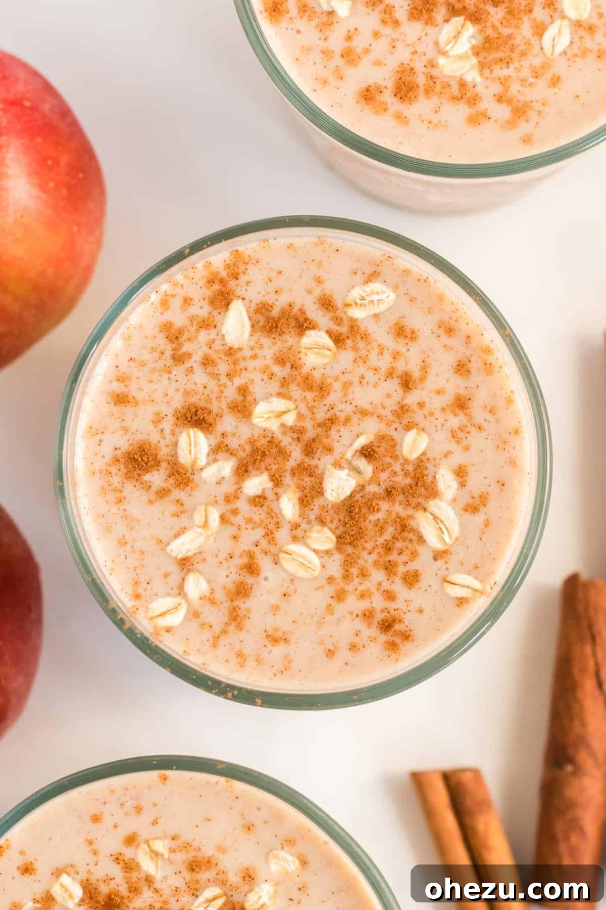 Another beautiful shot of the healthy apple pie smoothie in a glass, topped with cinnamon and oats, highlighting its rich texture.