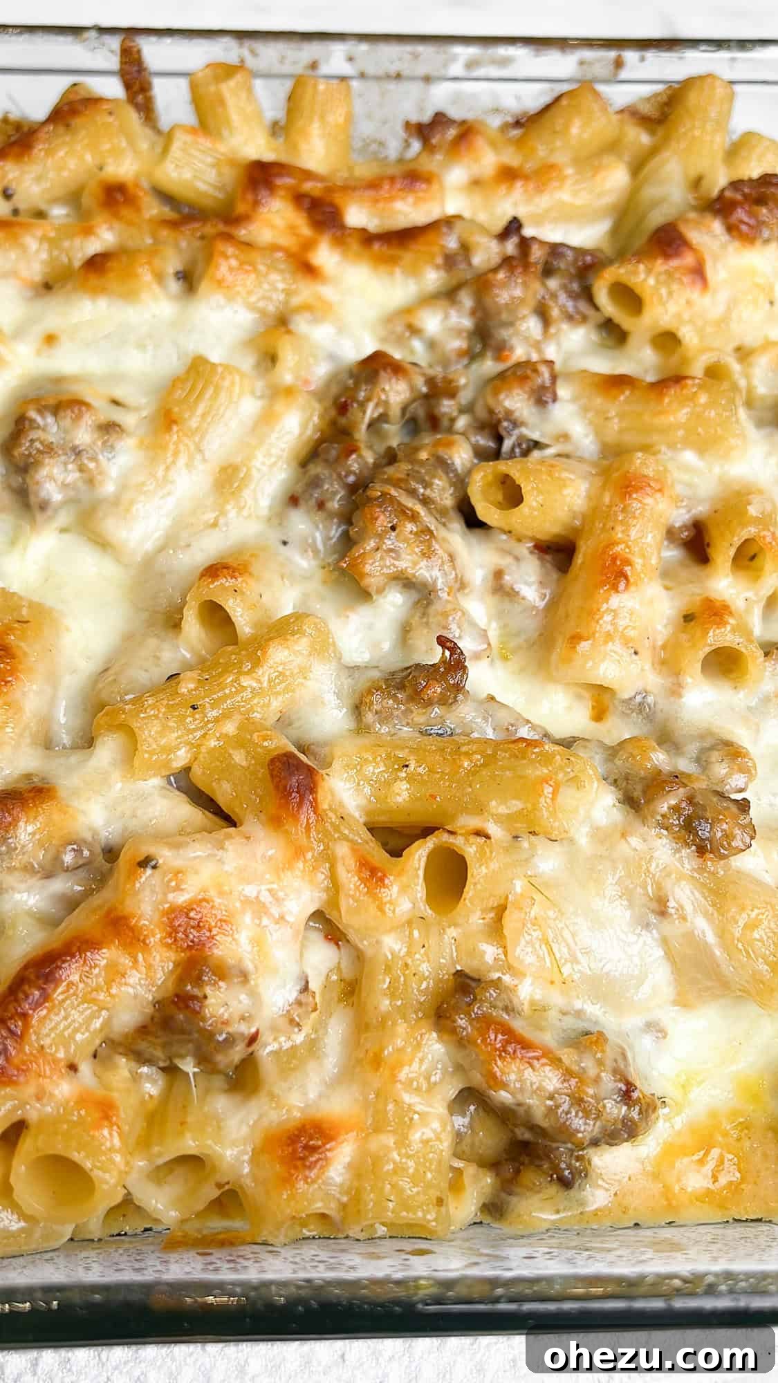 Hearty Creamy Sausage Alfredo Bake 11 serving of sausage alfredo bake in a bowl with garlic bread