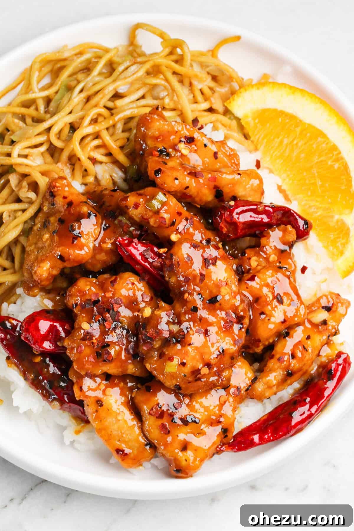 Hot Orange Chicken garnished with green onions and sesame seeds