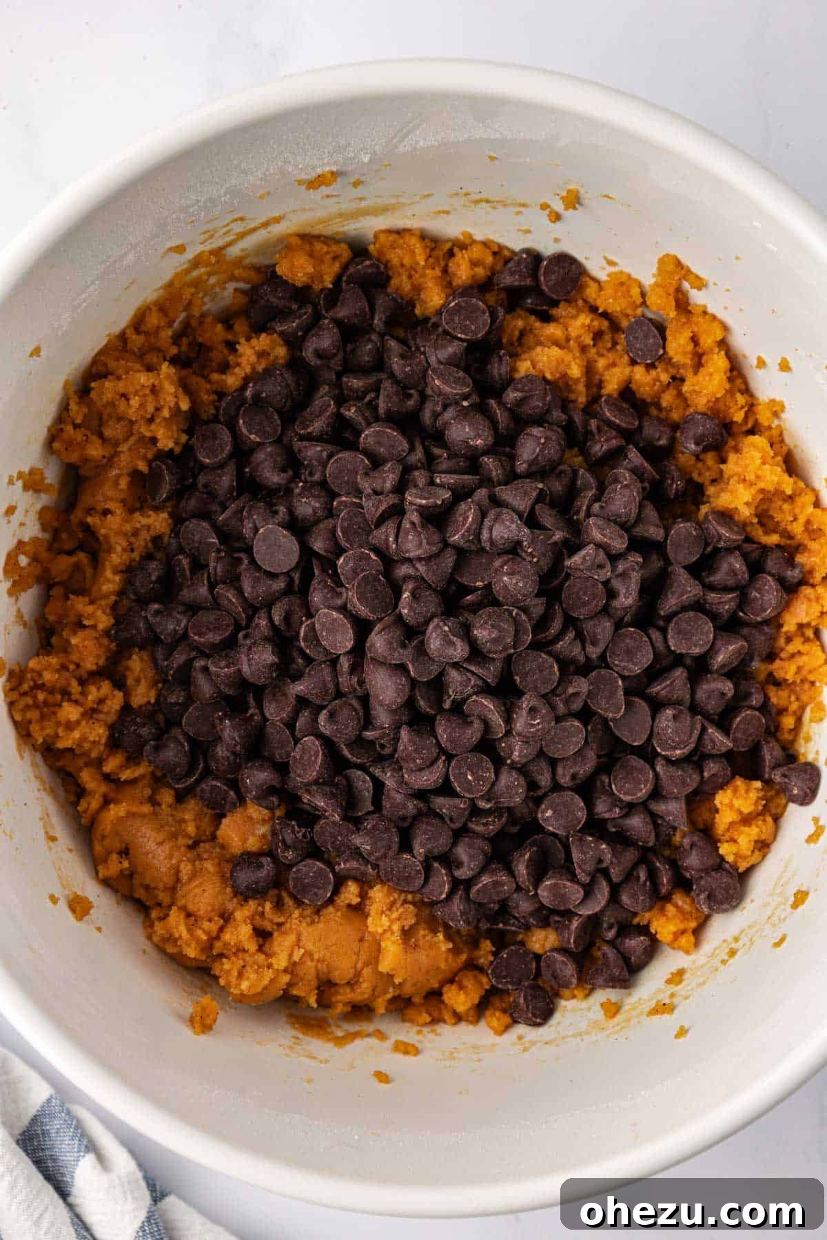 Adding dairy-free chocolate chips to cookie batter