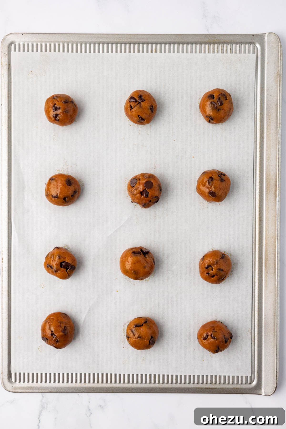 Vegan pumpkin chocolate chip cookie dough scoops on a baking sheet